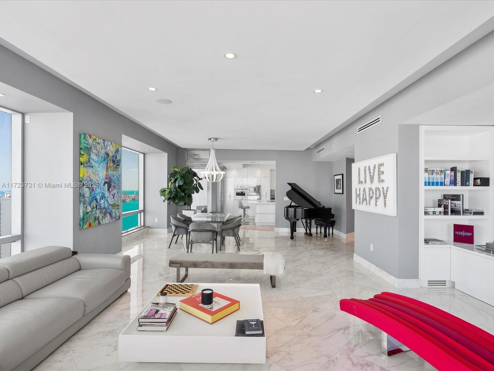 A modern living and dining area features marble floors, a grand piano, and ocean views — 1425 Brickell Ave, Miami FL 33131, MIAMI, FL