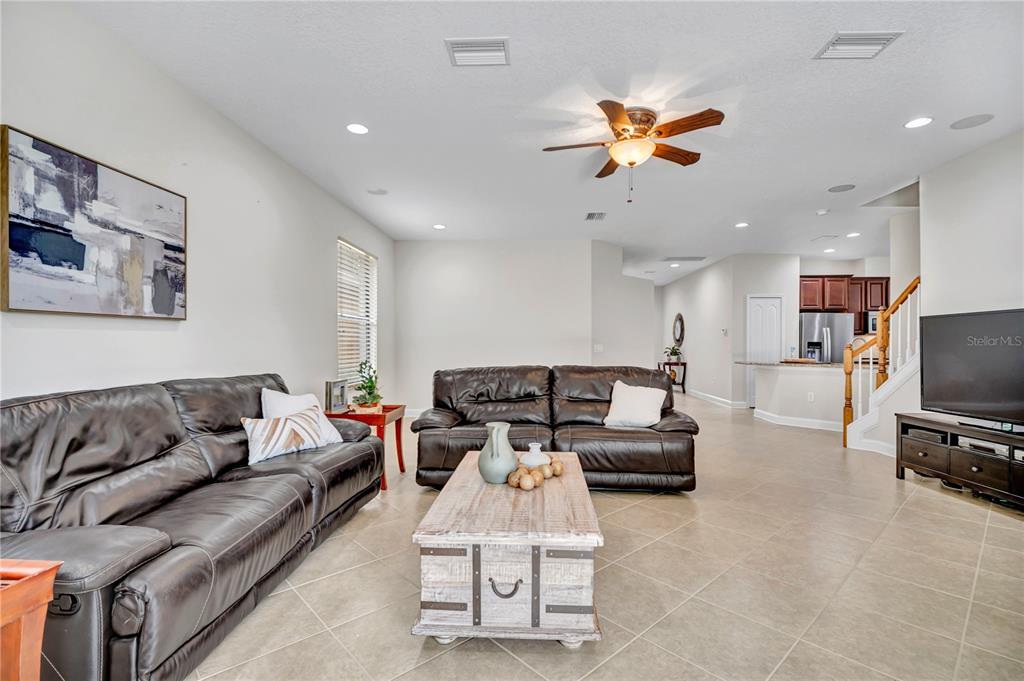 A living room features two dark leather sofas, a wooden coffee table, and tile flooring — 8013 HAMPTON GLEN DRIVE, TAMPA, FL