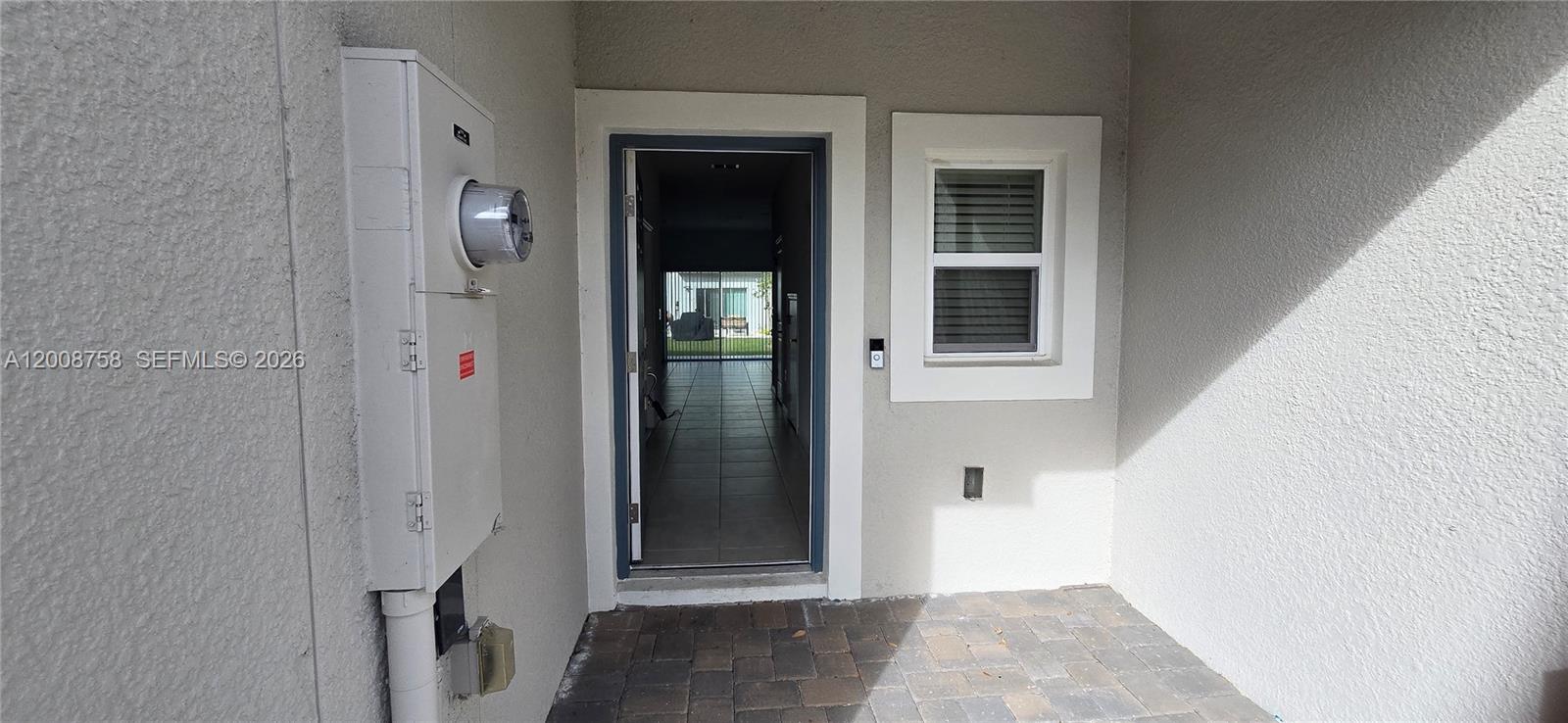 An exterior view shows a front entryway with a paved porch, electrical meter, and window — 2978 Canary Ave, Davenport FL 33837, DAVENPORT, FL