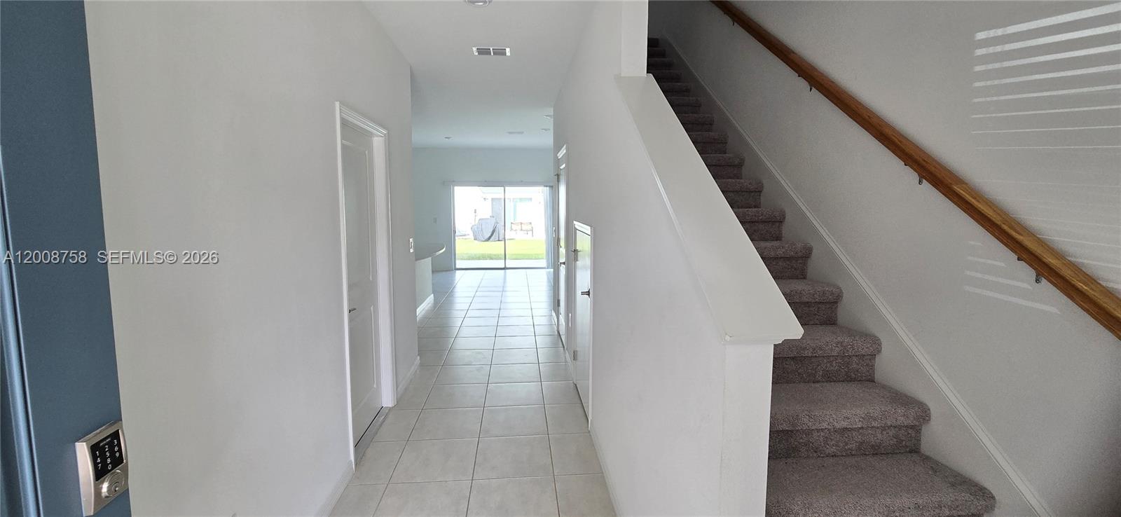 A tiled entryway leads to a living area with stairs and a sliding glass door — 2978 Canary Ave, Davenport FL 33837, DAVENPORT, FL