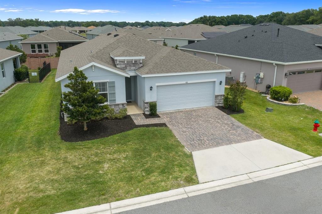 An aerial view of a light blue single-story house with a paver driveway and garage — 4313 NW 55TH COURT, OCALA, FL