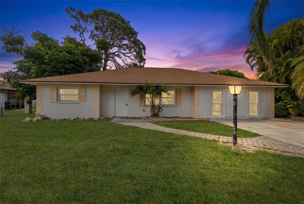 A single-story house with a light-colored exterior, a brown roof, and a paved walkway — 887 LEEWARD ROAD, VENICE, FL