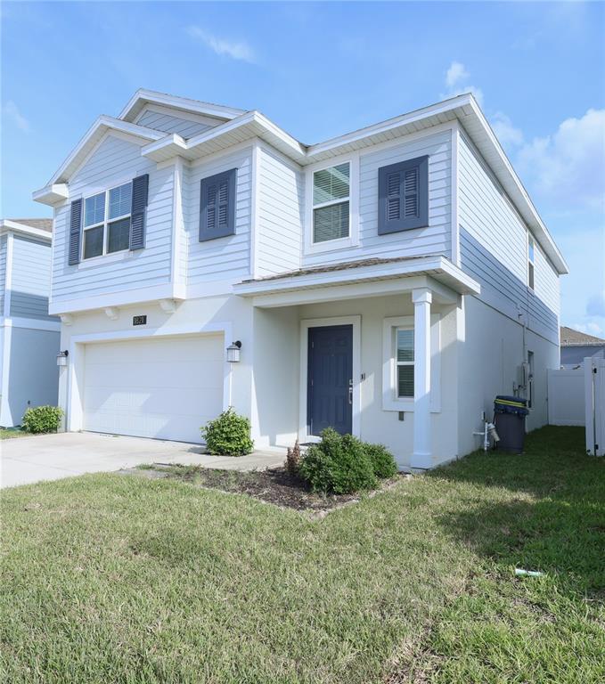 A two-story house with light blue siding, a white garage, and a dark blue front door — 1821 HEART LAKE DRIVE, GROVELAND, FL