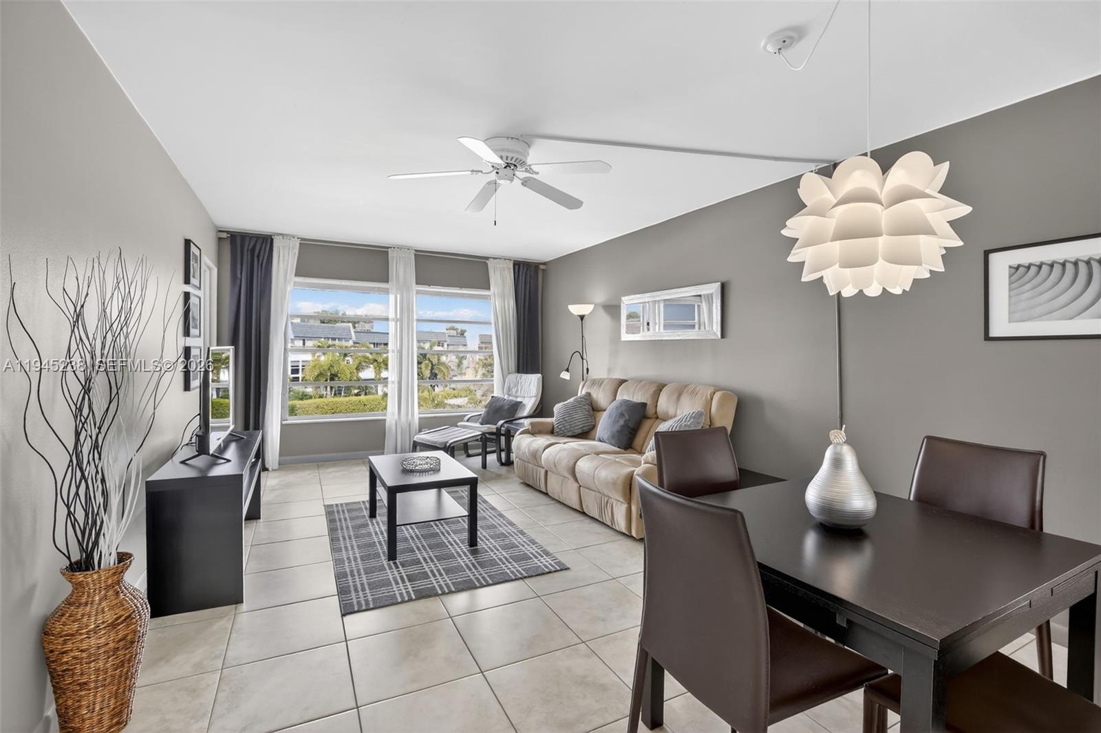 A living and dining area features tile floors, a ceiling fan, and a large window — 7897 Golf Circle Dr # 307, Margate FL 33063, MARGATE, FL