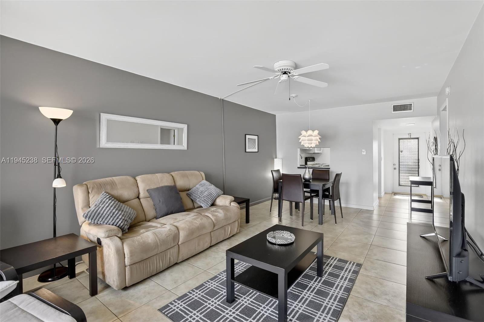 A living room features a beige sofa, a black coffee table, and a dining area — 7897 Golf Circle Dr # 307, Margate FL 33063, MARGATE, FL