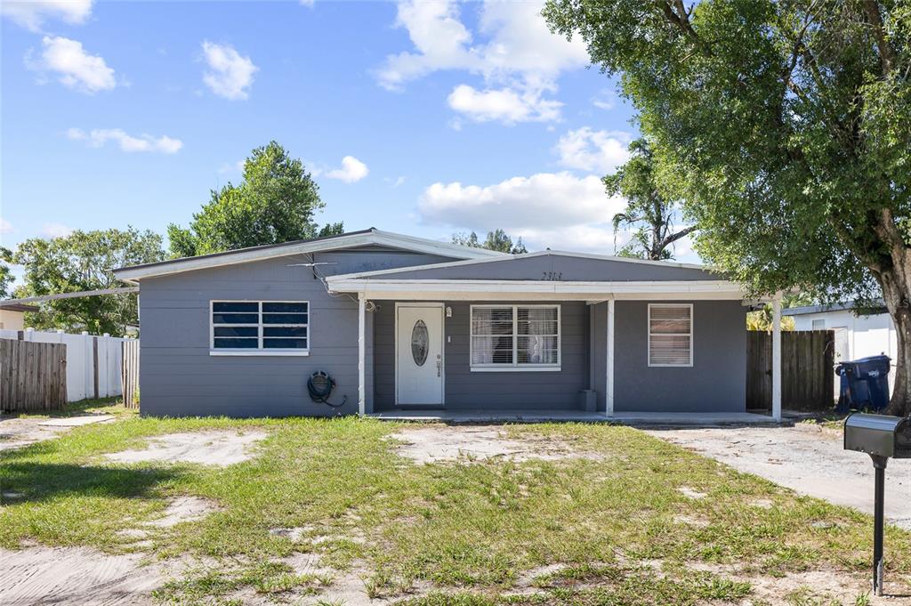A gray, single-story house with a white front door and a covered porch — 2313 E 111TH AVE, TAMPA, FL
