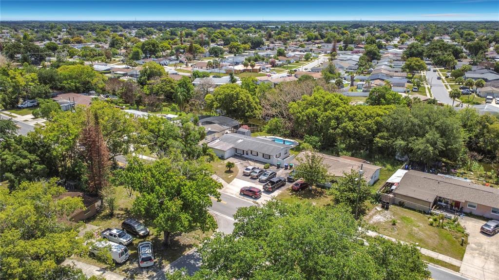 An aerial view shows a residential neighborhood with houses, trees, and parked cars — 7511 BROCKBANK DRIVE, ORLANDO, FL