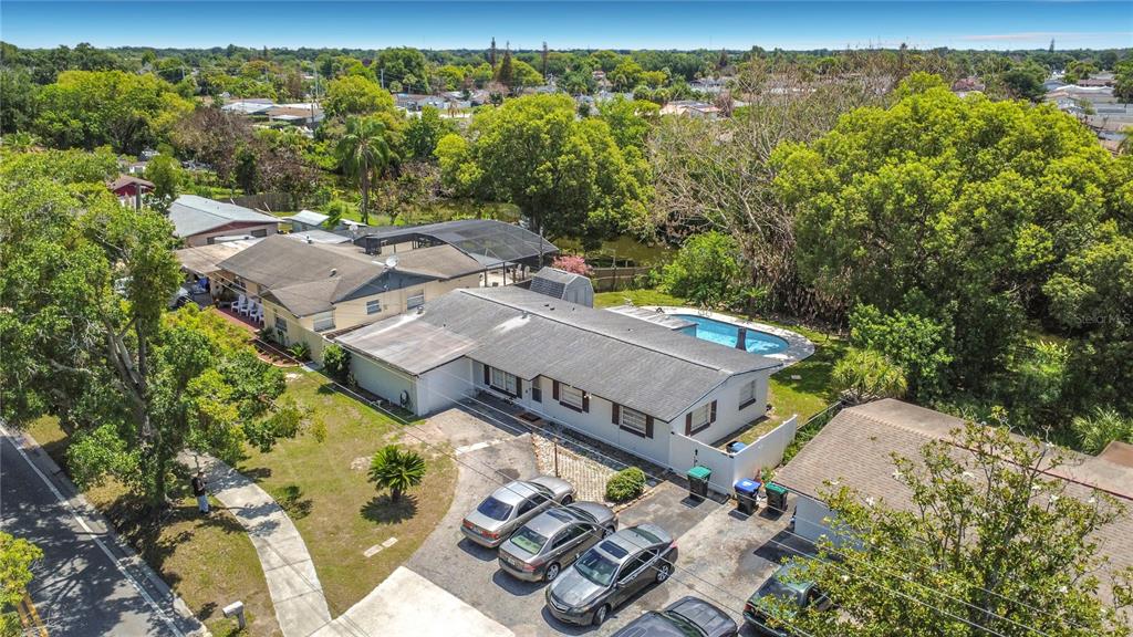 An aerial view shows a single-story house with a pool, driveway, and surrounding trees — 7511 BROCKBANK DRIVE, ORLANDO, FL