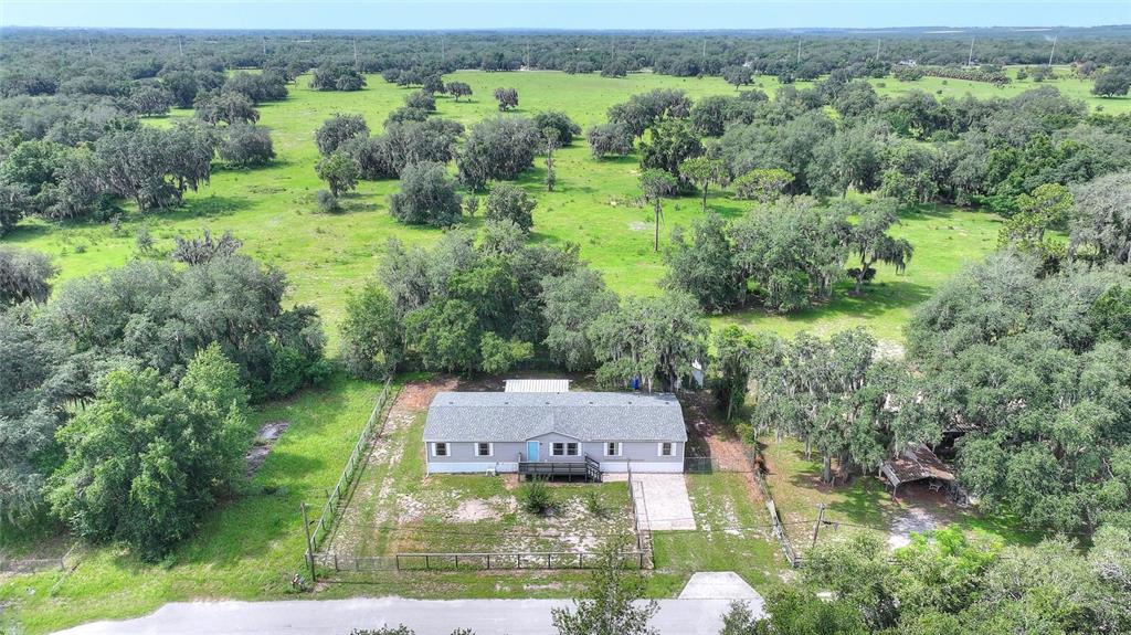 An aerial view shows a single-story house with a grey roof situated on a rural lot — 2524 CATFISH COURT, LAKE WALES, FL