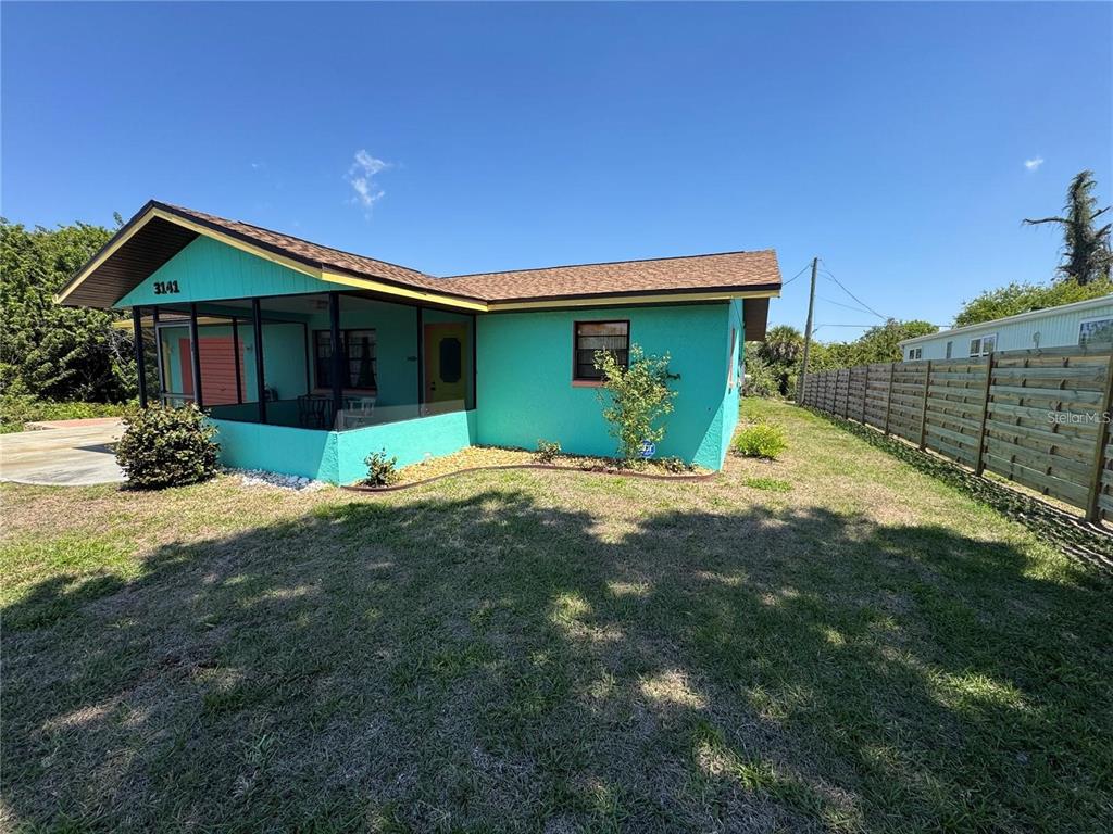 A turquoise house with a screened-in porch and a wooden fence in the yard — 3141 10TH STREET, ENGLEWOOD, FL