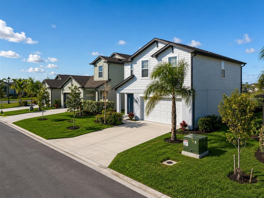 A two-story suburban house with a white facade, a garage, and a front lawn — 17809 BELFORTE COURT, NORTH FORT MYERS, FL