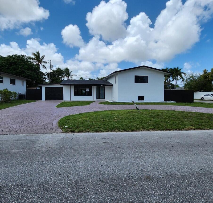 A single-story white house with a dark roof, garage, and a curved paved driveway — 1275 NE 200th Terrace, Miami FL 33179, MIAMI, FL