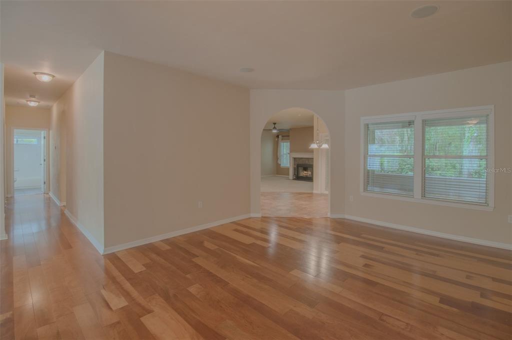 An interior view shows a living area with hardwood floors, an arched entryway, and windows — 8331 SW 75TH ROAD, GAINESVILLE, FL