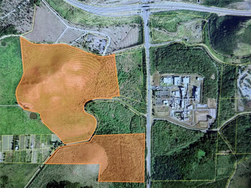 An aerial map shows two highlighted orange parcels of land separated by a road — POZO HONDO, GUAYAMA, PR