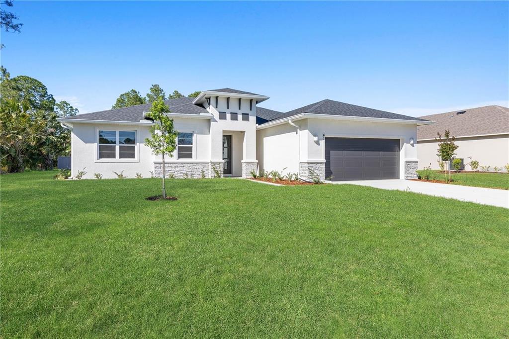 A single-story house with a white exterior, stone accents, and a two-car garage — 2235 SATURDAY STREET, NORTH PORT, FL