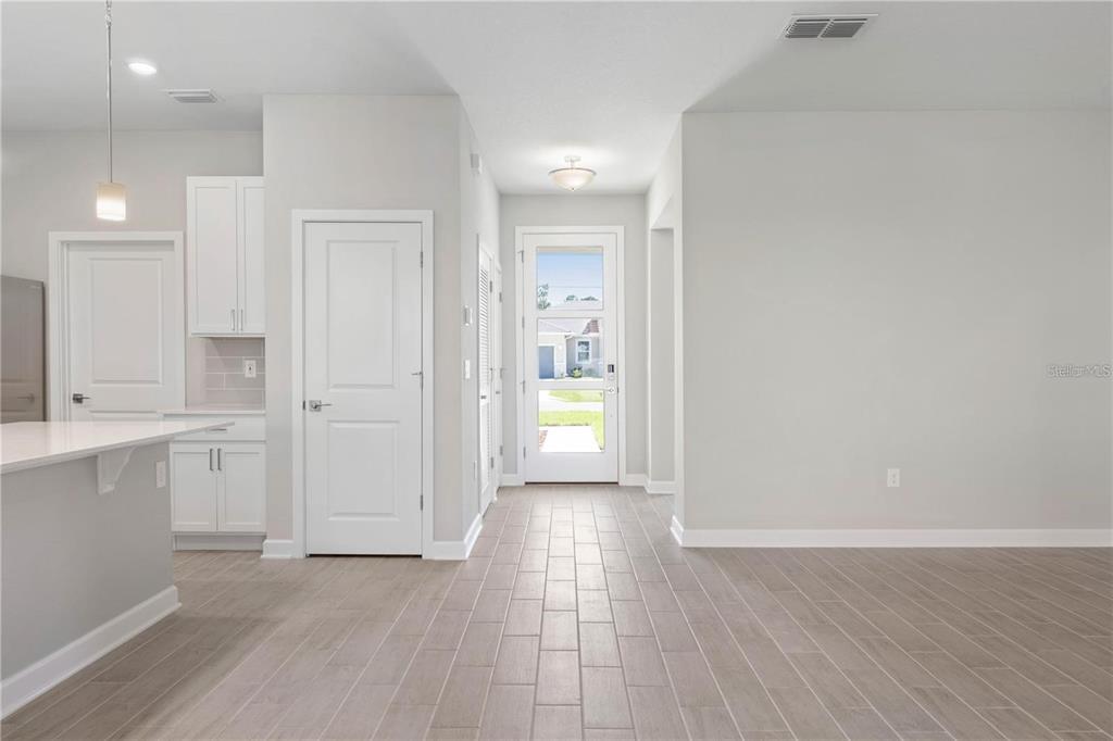 A bright entryway with light wood-look tile flooring leads to a glass-paneled front door — 2235 SATURDAY STREET, NORTH PORT, FL