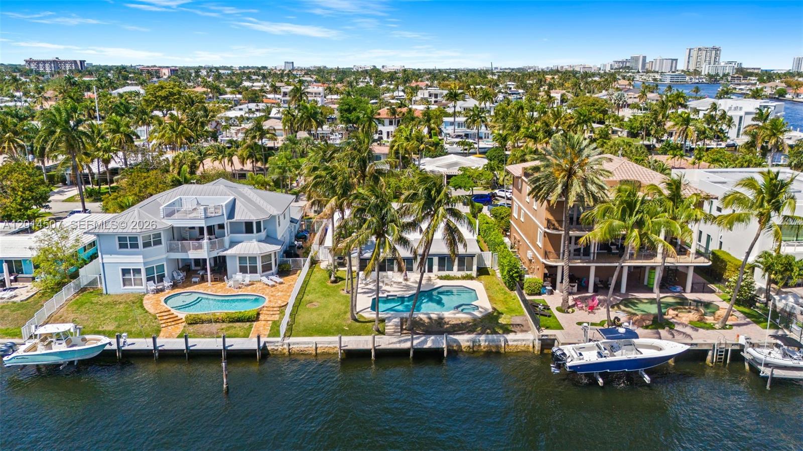 An aerial view shows three waterfront houses with private pools and docks along a canal — 2548 SE 12th St, Pompano Beach FL 33062, POMPANO BEACH, FL