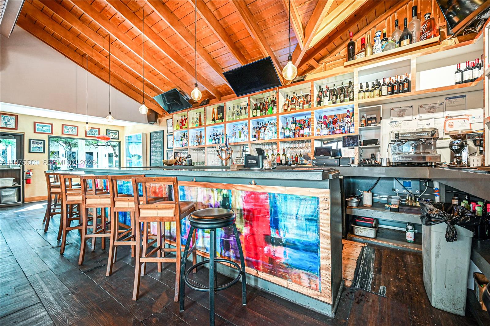 A rustic bar area features a wooden vaulted ceiling, colorful painted counter, and liquor shelving — 2426 NE 2nd Ave, Miami FL 33137, MIAMI, FL