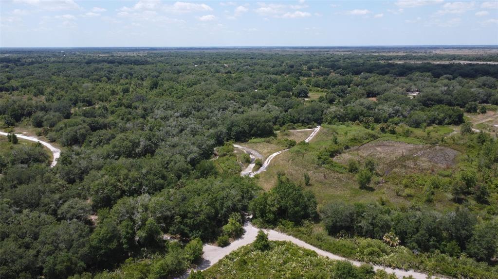 An aerial view shows a large, wooded plot of land with dirt paths and trails — 0 300th Street, Okeechobee FL 34972, OKEECHOBEE, FL