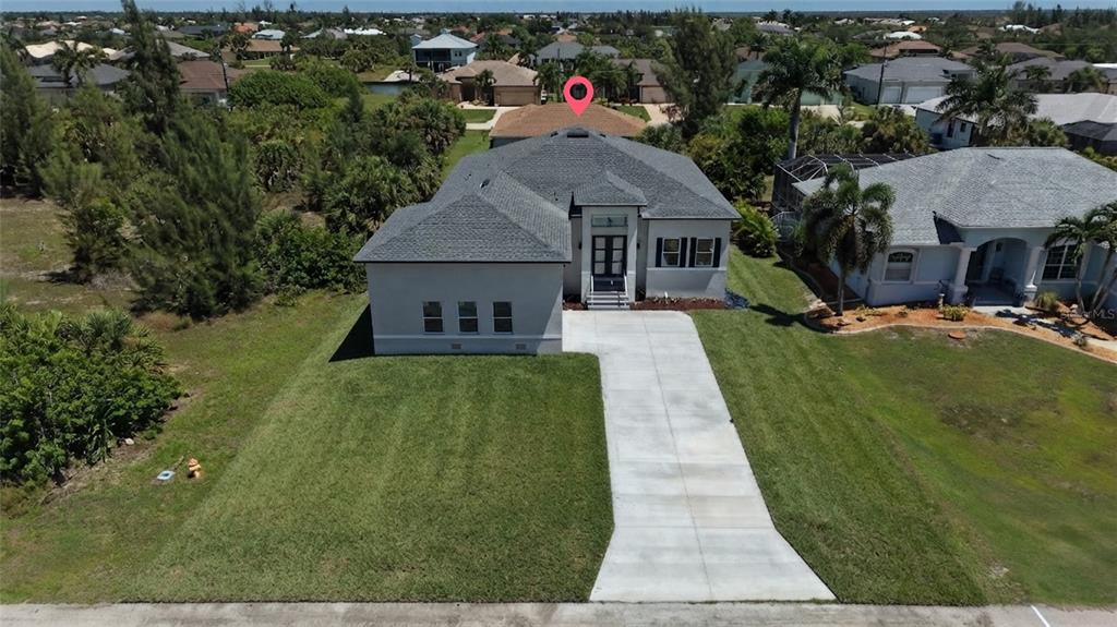 An aerial view shows a single-story house with a gray roof and concrete driveway — 15809 MELPORT CIRCLE, PORT CHARLOTTE, FL