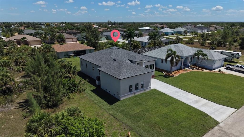An aerial view shows a single-story house with a gray roof and a concrete driveway — 15809 MELPORT CIRCLE, PORT CHARLOTTE, FL