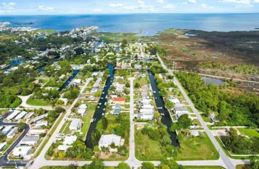 An aerial view shows a residential neighborhood with houses situated along canals near the coast — LOTS 13 & 14 SHEEPSHEAD DRIVE, HUDSON, FL