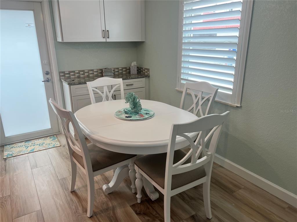 A white dining table with four chairs sits in a kitchen with light-colored cabinetry — 6154 MIDNIGHT PASS ROAD UNIT D16, SARASOTA, FL