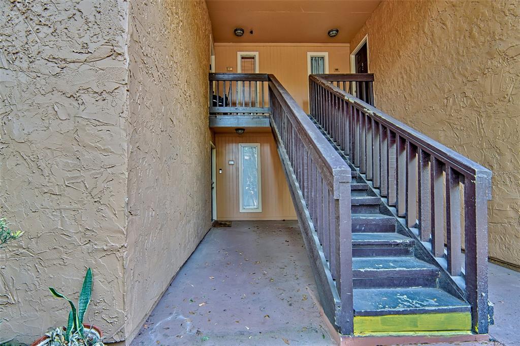An outdoor staircase leads to a second-floor balcony with two apartment entry doors — 1810 NW 23RD BOULEVARD UNIT 188, GAINESVILLE, FL