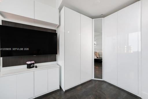 A modern room features a wall-mounted television, white cabinetry, and a mirrored closet door — 92 SW 3rd St # 5108, Miami FL 33130, MIAMI, FL