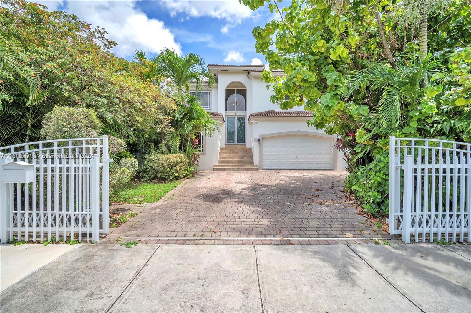 A two-story house with a paved driveway, arched entryway, and a white garage door — 2913 SW 13th St, Miami FL 33145, MIAMI, FL