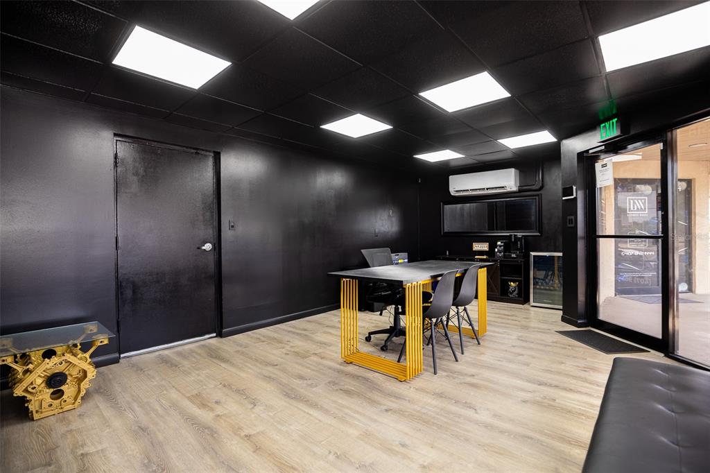 A modern office space features black walls, a yellow-legged desk, and light wood flooring — 1318 SPRUCE AVENUE UNIT 1345b, ORLANDO, FL