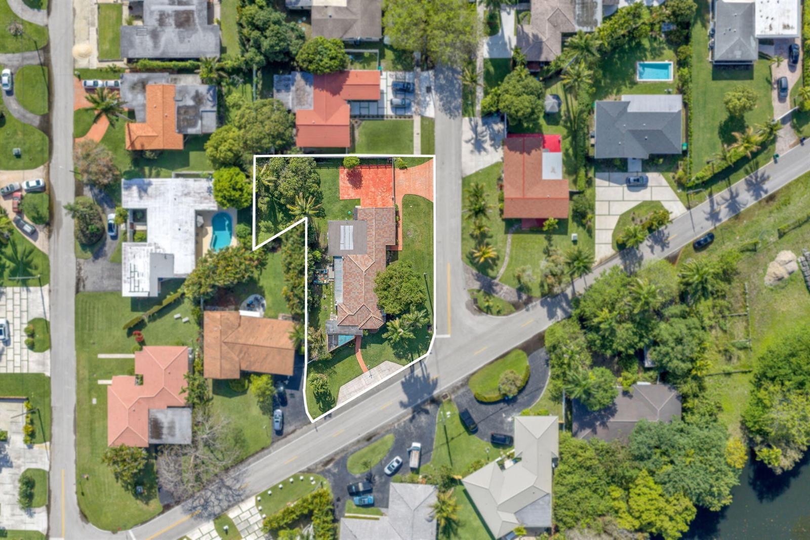 An aerial view shows a residential property with a tiled roof and a swimming pool — 11490 W Biscayne Canal Road, Miami FL 33161, MIAMI, FL