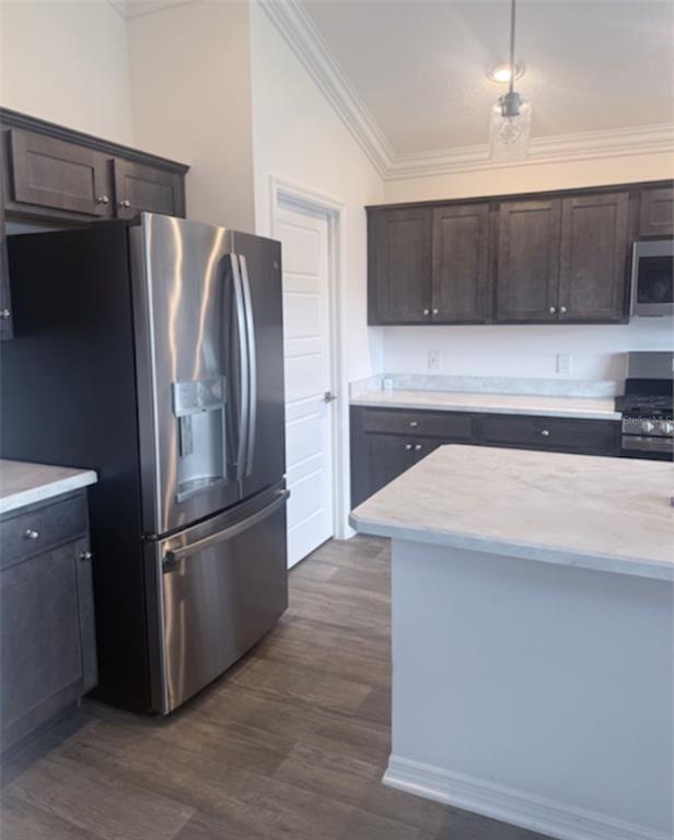 A kitchen features dark wood cabinets, stainless steel appliances, and a white marble-look island — 2790 CARYTOWN LOOP, THE VILLAGES, FL