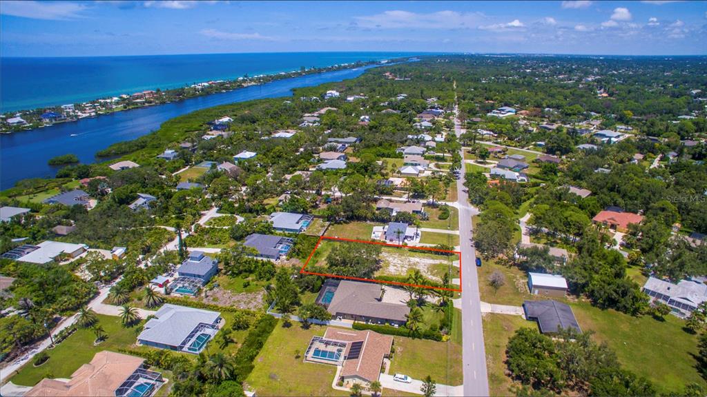 An aerial view shows a vacant residential lot outlined in red along a paved road — 2450 ALAMANDER AVENUE, ENGLEWOOD, FL