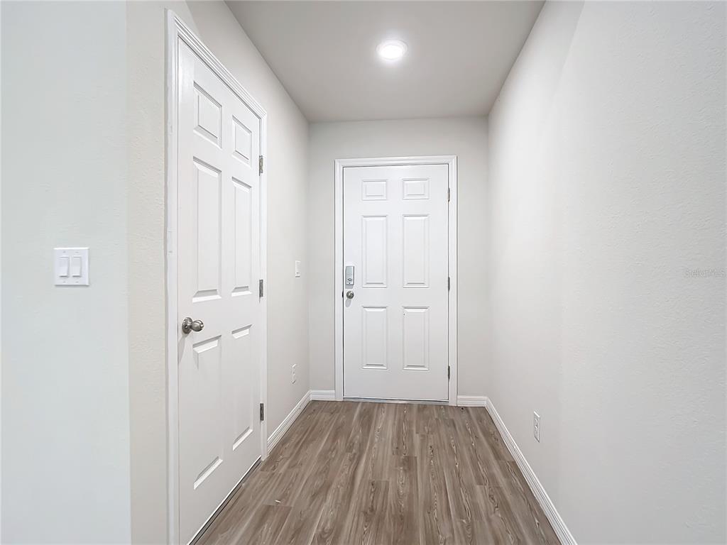 A small entryway features light gray walls, wood-look flooring, and two white six-panel doors — 17053 NIXON AVENUE, PORT CHARLOTTE, FL