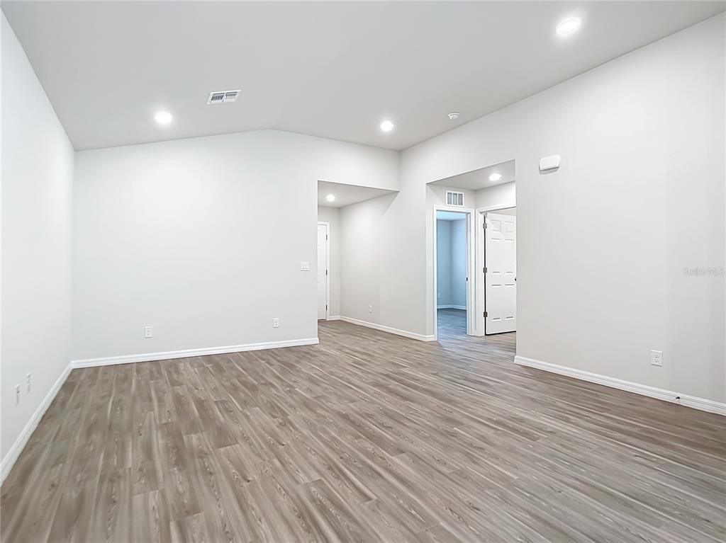 An empty room with light gray walls, recessed lighting, and wood-look vinyl plank flooring — 17053 NIXON AVENUE, PORT CHARLOTTE, FL