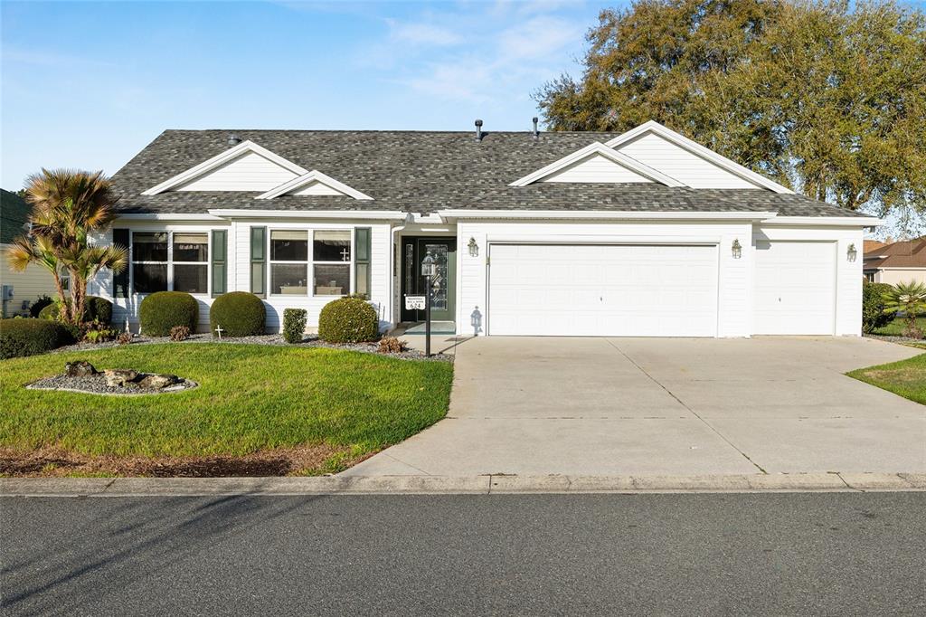 A single-story house with white siding, a gray shingled roof, and an attached three-car garage — 624 FAYETTE COURT, THE VILLAGES, FL