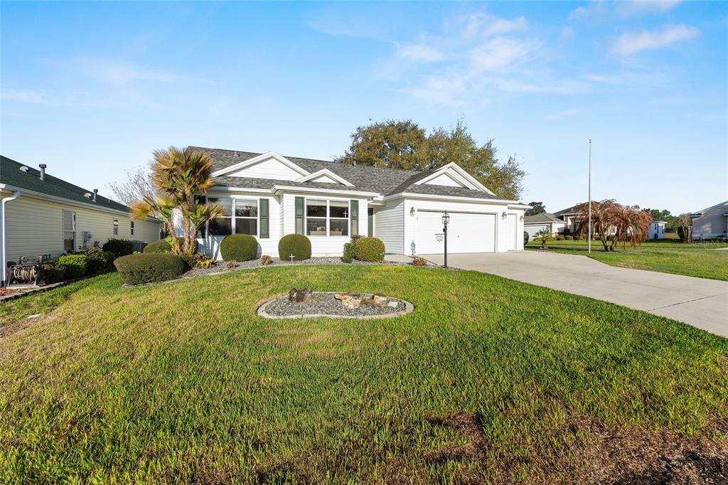 A single-story house with white siding, a two-car garage, and a landscaped front lawn — 624 FAYETTE COURT, THE VILLAGES, FL
