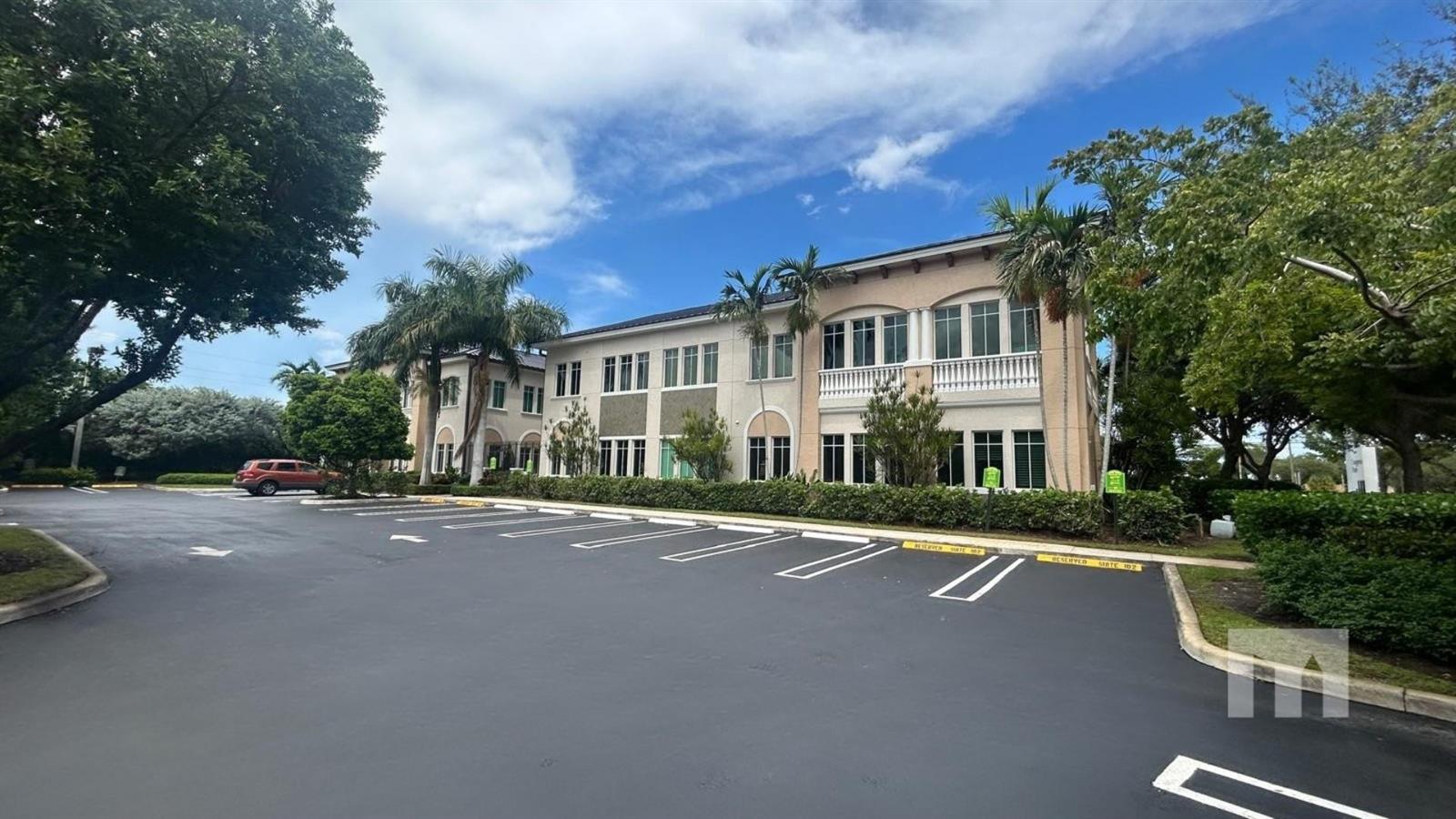 A two-story commercial building with a parking lot in the foreground and palm trees — 160 Congress Park Drive # 111, Delray Beach FL 33445, DELRAY BEACH, FL