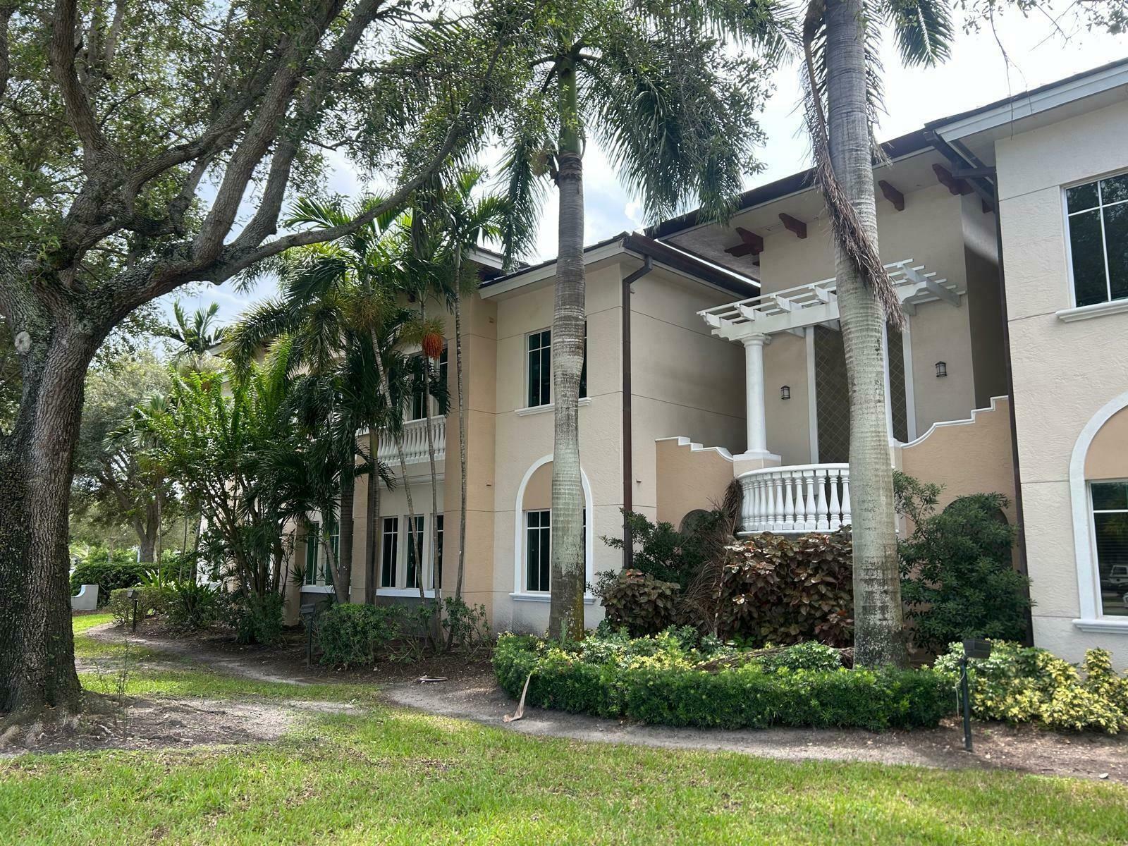 A two-story stucco building with palm trees, a balcony, and a pergola entrance — 160 Congress Park Drive # 111, Delray Beach FL 33445, DELRAY BEACH, FL