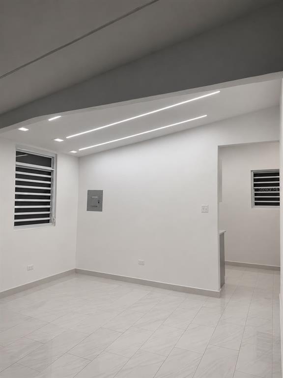 A minimalist room with white walls, light tile flooring, recessed lighting, and two windows — . 26 UNIT M25, CAROLINA, PR