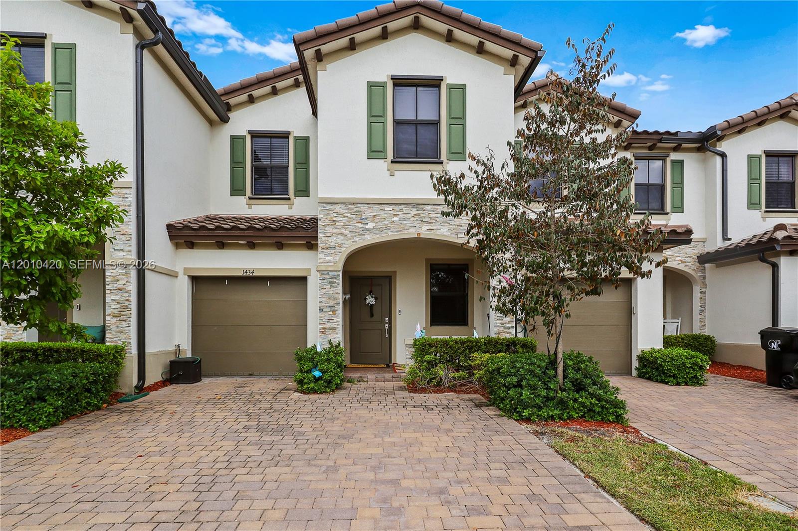 A two-story townhouse with a stone facade, arched entryway, and two attached garages — 1434 SW 54th Ave, North Lauderdale FL 33068, NORTH LAUDERDALE, FL