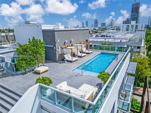 A rooftop terrace features a swimming pool, lounge chairs, cabanas, and views of a city skyline — 1215 West Ave # 203, Miami Beach FL 33139, MIAMI BEACH, FL