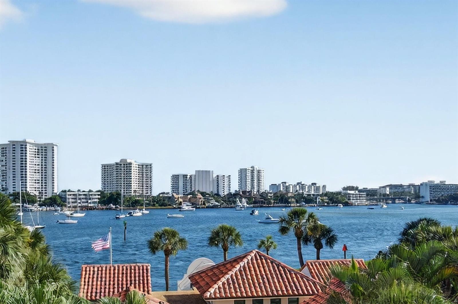A view of a bay with boats, palm trees, and high-rise buildings in the distance — 140 SE 5th Avenue # 448, Boca Raton FL 33432, BOCA RATON, FL