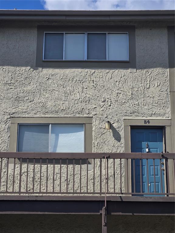 A blue front door labeled B4 is visible on the exterior of a stucco building — 6305 NEWTOWN CIRCLE UNIT 5B4, TAMPA, FL