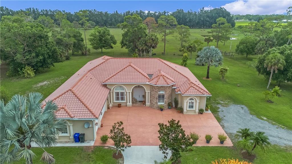 An aerial view of a single-story house with a red tile roof and paved driveway — 10750 146th Avenue, Fellsmere FL 32948, FELLSMERE, FL