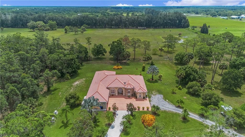 An aerial view shows a single-story house with a red tile roof and a concrete driveway — 10750 146th Avenue, Fellsmere FL 32948, FELLSMERE, FL