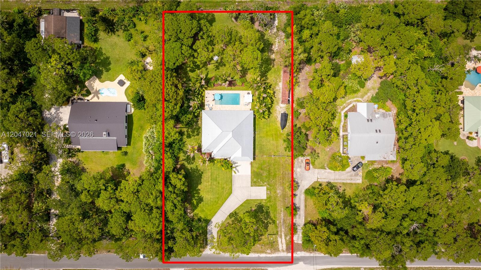 An aerial view shows a house with a pool on a large, tree-lined lot — 12127 N 154th Rd N, Jupiter FL 33478, JUPITER, FL
