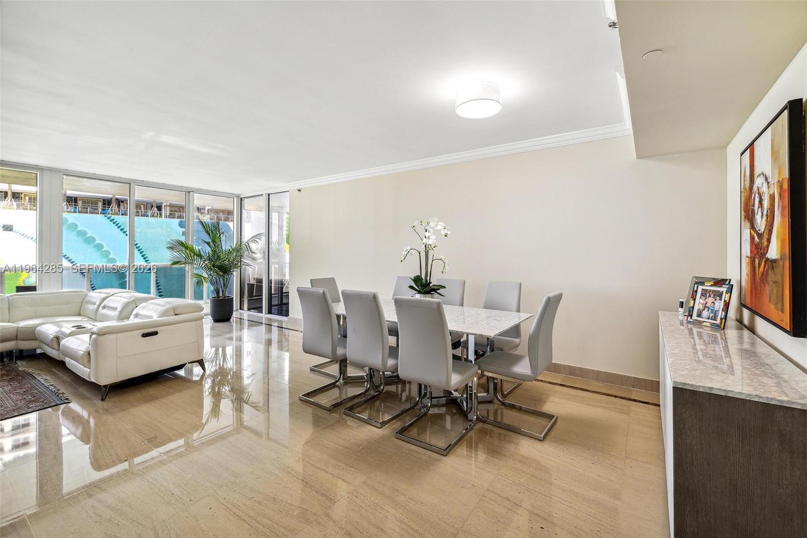 A dining area with a marble table and chairs sits next to a white sofa — 1800 S Ocean Dr # 1010, Hallandale Beach FL 33009, HALLANDALE BEACH, FL