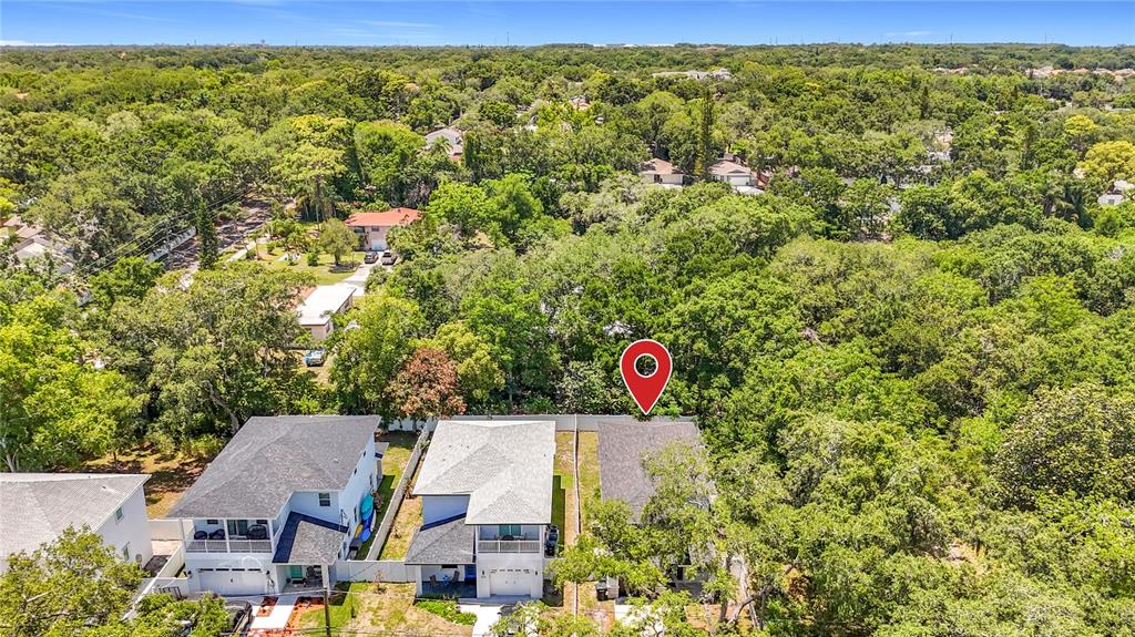 An aerial view shows three houses surrounded by dense trees with a red location pin — 525 ELM STREET, SAFETY HARBOR, FL